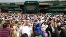 Ribuan penonton tengah serius menonton lewat layar besar laga Andy Murray melawan Milos Raonic pada final tunggal putra  Wimbledon Championships 2016 di The All England Lawn Tennis Club,  Wimbledon, London, (10/7/2016).  (AFP/Justin Tallis)