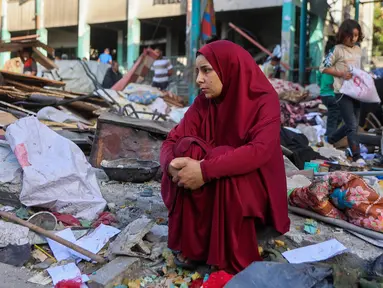 Seorang wanita duduk di antara reruntuhan di sekolah Fahmi Al-Jarjawi, kota Gaza, pada 26 Mei 2025. (Omar AL-QATTAA/AFP)