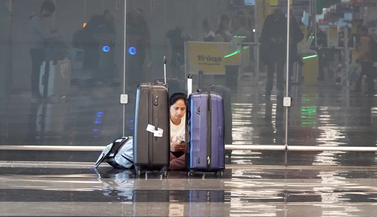 Seorang pelancong menunggu penerbangan di Bandara Internasional O'Hare di Chicago (22/12/2022). Administrasi Penerbangan Federal memperingatkan bahwa angin kencang dan salju lebat dapat menunda penerbangan di pusat perjalanan udara utama Minneapolis-St. Paul, Chicago dan Denver. (Scott Olson/Getty Images/AFP)