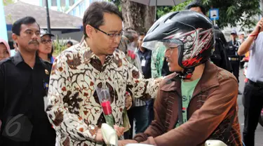 Kepala BPOM RI Roy Sparringa membagikan bunga Mawar di jalan Percetakan Negara  dalam aksi simpatik BPOM RI, Jakarta, Senin (1/6/2015). Kampaye ini dalam dukungan Gerakan Nasional Waspada Obat dan Makanan ilegal. (Liputan6.com/Helmi Afandi)