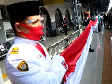 Personil Paskibra membentangkan bendera Merah Putih di Stasiun Pasar Senen, Jakarta, Senin (17/8/2020). Dalam rangka peringatan ke-75 tahun Hari Kemerdekaan Indonesia, PT KAI Daop 1 Jakarta mengadakan upacara pembentangan Bendera Merah Putih sepanjang 17 meter. (Liputan6.com/Helmi Fithriansyah)