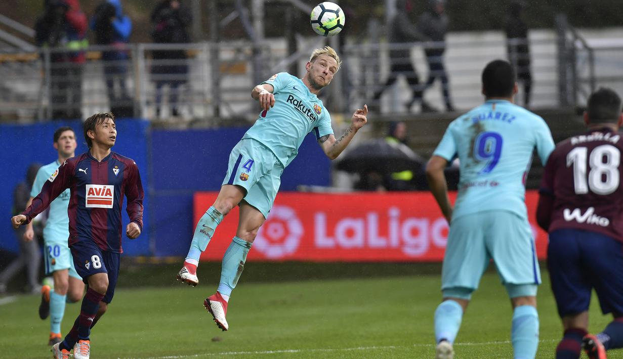 Pemain FC Barcelona, Ivan Rakitic menghalau bola dari kejaran pemain SD Eibar, Takashi Inui pada lanjutan La Liga Santander di Ipurua stadium,  Eibar, (17/2/2018). Barcelona menang 2-0.(AP/Alvaro Barrientos)