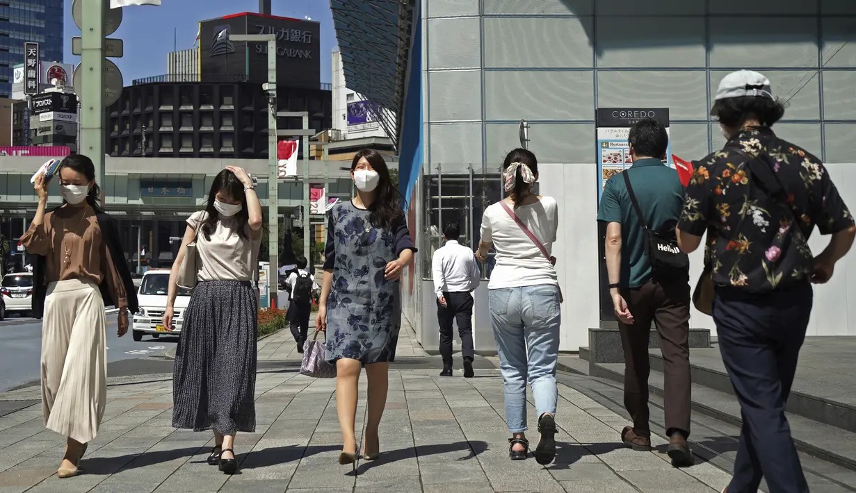 Orang-orang yang memakai masker melintasi persimpangan di Tokyo Kamis (5/8/2021). Tokyo pada hari Kamis melaporkan 5.042 kasus virus corona baru, rekor tertinggi harian terbaru sejak pandemi Covid-19 dimulai, di saat ibu kota Jepang menjadi tuan rumah Olimpiade. (AP Photo/Kantaro Komiya)