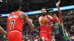 Aksi Nikola Mirotic (44) memberikan umpan kepada rekannya saat melewati pemain Boston Celtics, Al Horford (kanan) pada lanjutan NBA basketball game di United Center, Chicago, (11/12/2017). Bulls menang 108-85. (AP/Charles Rex Arbogast)