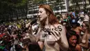Rachel Jessee berorasi sambil bertelanjang dada dalam parade GoTopless di Manhattan, New York City, Minggu (23/8/2015). Aksi tersebut menuntut persamaan hak untuk bertelanjang dada seperti pria. (Kena Betancur/Getty Images/AFP)