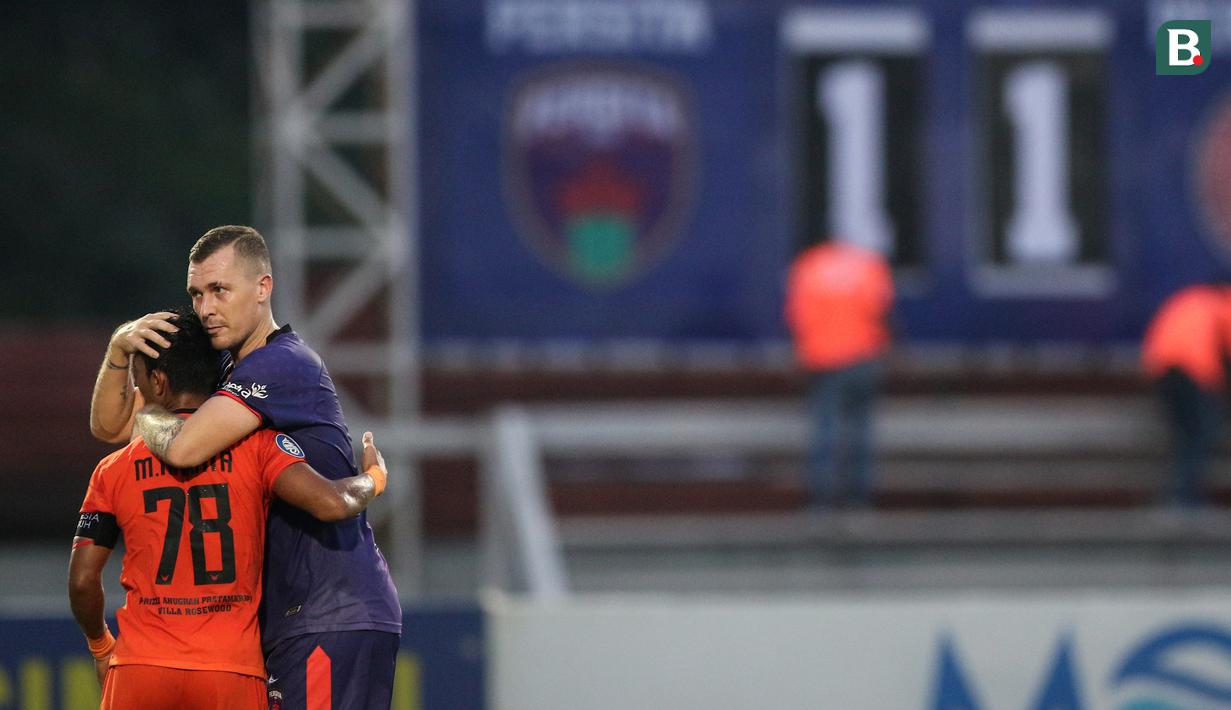 Pemain Persita Tangerang, Adam Thomas Mitter (kanan) dan pemain Persiraja Banda Aceh, Mukhlis berpelukan usai berakhirnya laga pekan ke-7 BRI Liga 1 2021/2022 di Stadion Moch Soebroto, Magelang, Sabtu (16/10/2021). (Bola.com/Bagaskara Lazuardi)