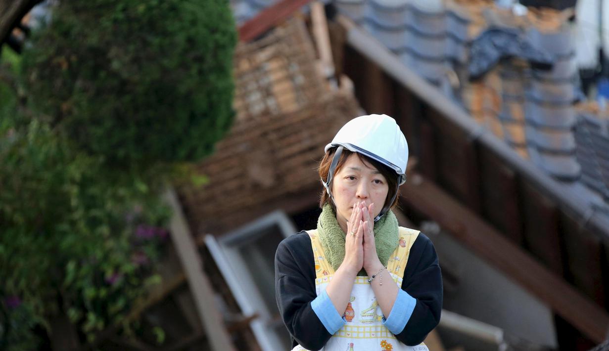 Seorang warga Jepang bersedih usai rumahnya hancur akibat gempa bumi di kota Mashiki, Prefektur Kumamoto, Jepang selatan, Sabtu (16/4). Gempa berkekuatan 6,4 SR itu menewaskan sembilan orang dan 760 lainnya terluka. (REUTERS/Kyodo)