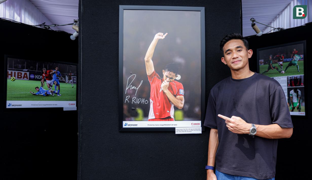 <p>Pemain Timnas Indonesia, Rizky Ridho berfoto bersama dengan karya foto milik Ady Sesotya yang memperlihatkan dirinya tengah berselebrasi mencium logo garuda di jerseynya setelah Skuad Garuda menang 1-0 atas Bahrain di Kualifikasi Piala Dunia 2026 saat pameran foto Media Cup 2025 bertema "Timnas Indonesia dari Masa ke Masa" di Cibis, Cilandak, Jakarta Selatan, Selasa (28/10/2025). (Bola.com/Bagaskara Lazuardi)</p>