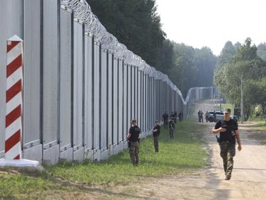 Penjaga perbatasan Polandia berpatroli di area tembok baja yang baru dibangun di perbatasan antara Polandia dan Belarusia, dekat Kuznice, Kamis (30/6/2022). Perdana Menteri Polandia Mateusz Morawiecki mengunjungi daerah perbatasan untuk menandai selesainya pembangunan tembok baja baru. (AP Photo/Michal Dyjuk)