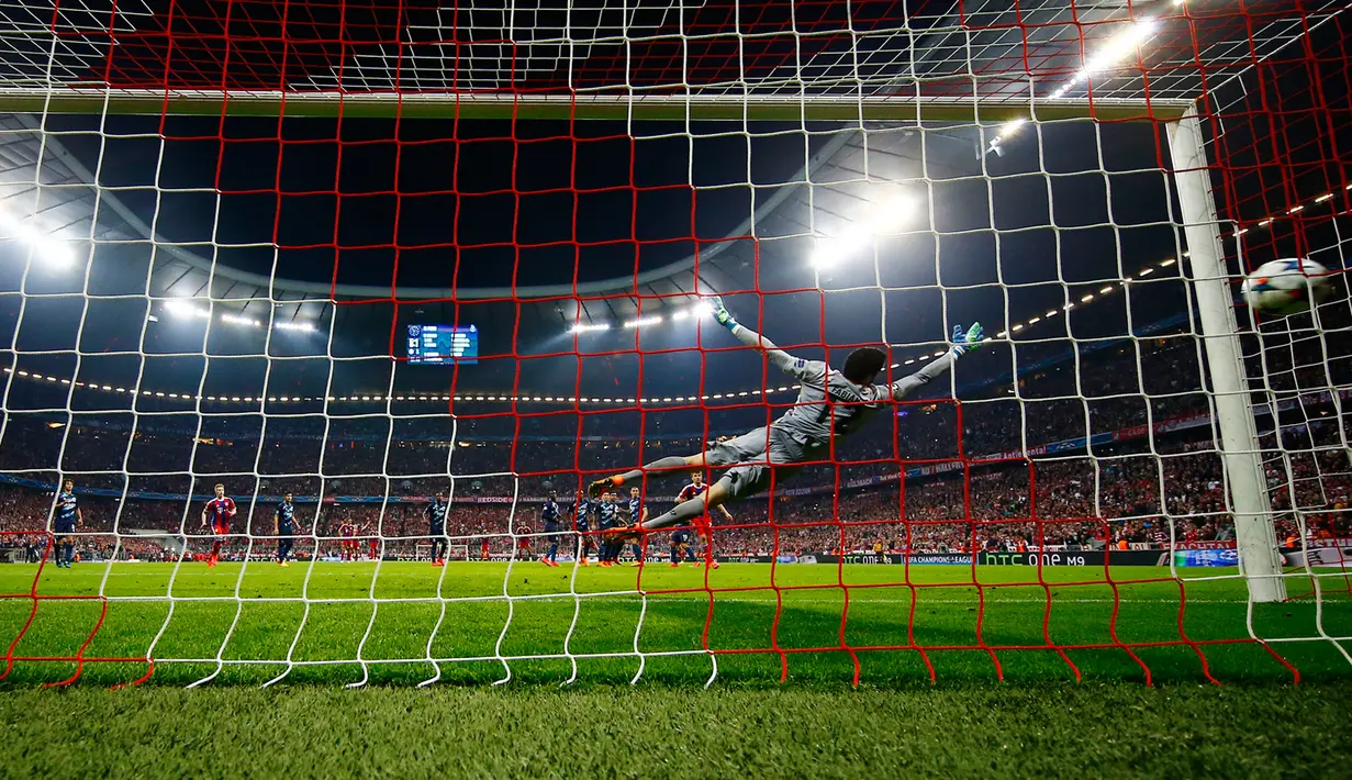 Kiper Porto, Fabiano gagal menghalau tendangan gelandang  Bayern Muenchen  Xabi Alonso pada leg kedua perempat final Liga Champions di Allianz Arena, German, Rabu (22/4/2015). Bayern Muenchen menang 6-1 atas Porto. (Reuters/Kai Pfaffenbach)