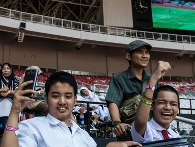 Sejumlah pelajar YPAC memberikan dukungan kepada atlet-atlet yang berlaga pada ajang Asian Para Games di SUGBK, Jakarta, Senin (8/10). Anak-anak terlihat bahagia dapat mendukung langsung di stadion. (Bola.com/Vitalis Yogi Trisna)