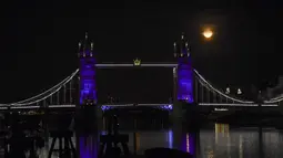 Bulan purnama terlihat di atas Tower Bridge, London, Inggris, Kamis (7/5/2020). Fenomena supermoon atau di belahan Bumi lain disebut flower moon ini merupakan yang terakhir di tahun 2020. (AP Photo/Alberto Pezzali)