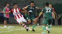 Pemain Persepam Madura United, Rossi Noprihanis (kiri) dihadang pemain PSS Sleman, Wawan Widiantoro pada laga Piala Kemerdekaan di Stadion Wilis, Madiun, Sabtu (15/08/2015). Persepam berhasil taklukan PSS 2-0. (Bola.com/Robby Firly)