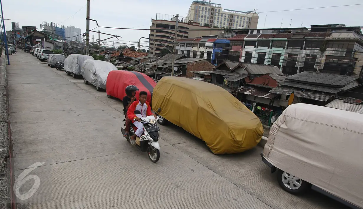 Deretan mobil parkir di jalur inspeksi Kanal Banjir Barat, Jakarta, Senin (6/3). Keterbatasan lahan menyebabkan pemilik kendaraan memarkirkan kendaraannya di tempat tersebut, meskipun telah terpampang larangan parkir. (Liputan6.com/Immanuel Antonius)