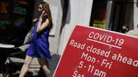 Pejalan kaki berjalan melewati tanda yang menunjukkan jalan ditutup di daerah Soho, pusat kota London, Kamis (3/6/2021). Pemerintah Inggris belum bisa memastikan akan sepenuhnya mencabut lockdown yang berakhir pada 21 Juni nanti meski kasus Covid-19 mengalami tren penurunan. (Tolga Akmen/AFP)
