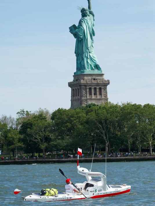 Aleksander Doba mengayuh kayaknya dengan latar belakang Patung Liberty, New York, Minggu (29/5). Rencananya ia akan mendayaung kayak dari New York ke Lisbon, Portugal. (AFP Photo/Eduardo Munoz)