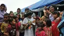 Tegar yang muncul dengan topi dan kacamata hitam mampu menghibur para korban erupsi gunung Sinabung terutama anak-anak (Liputan6.com/Johan Tallo).