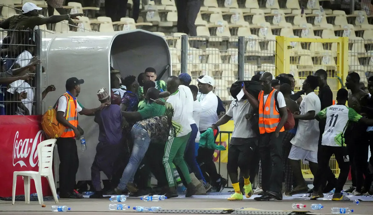 Pemain Ghana berlari keluar lapangan setelah diserbu pada akhir pertandingan kualifikasi Piala Dunia 2022 melawan Nigeria di Stadion Moshood Abiola, Abuja, Nigeria, 29 Maret 2022. Fans Nigeria ngamuk setelah gagal lolos ke Piala Dunia 2022. (AP Photo/Sunday Alamba)