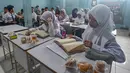 Tote bag ini dibuat dua warna berbeda agar mudah diidentifikasi dalam distribusi MBG antara periode pertama ke periode selanjutnya. Tampak dalam foto, siswa menerima makanan program Makan Bergizi Gratis (MBG) Ramadan di SDI Al Hidayah, Cinere, Depok, Selasa (24/2/2026). (merdeka.com/Arie Basuki)