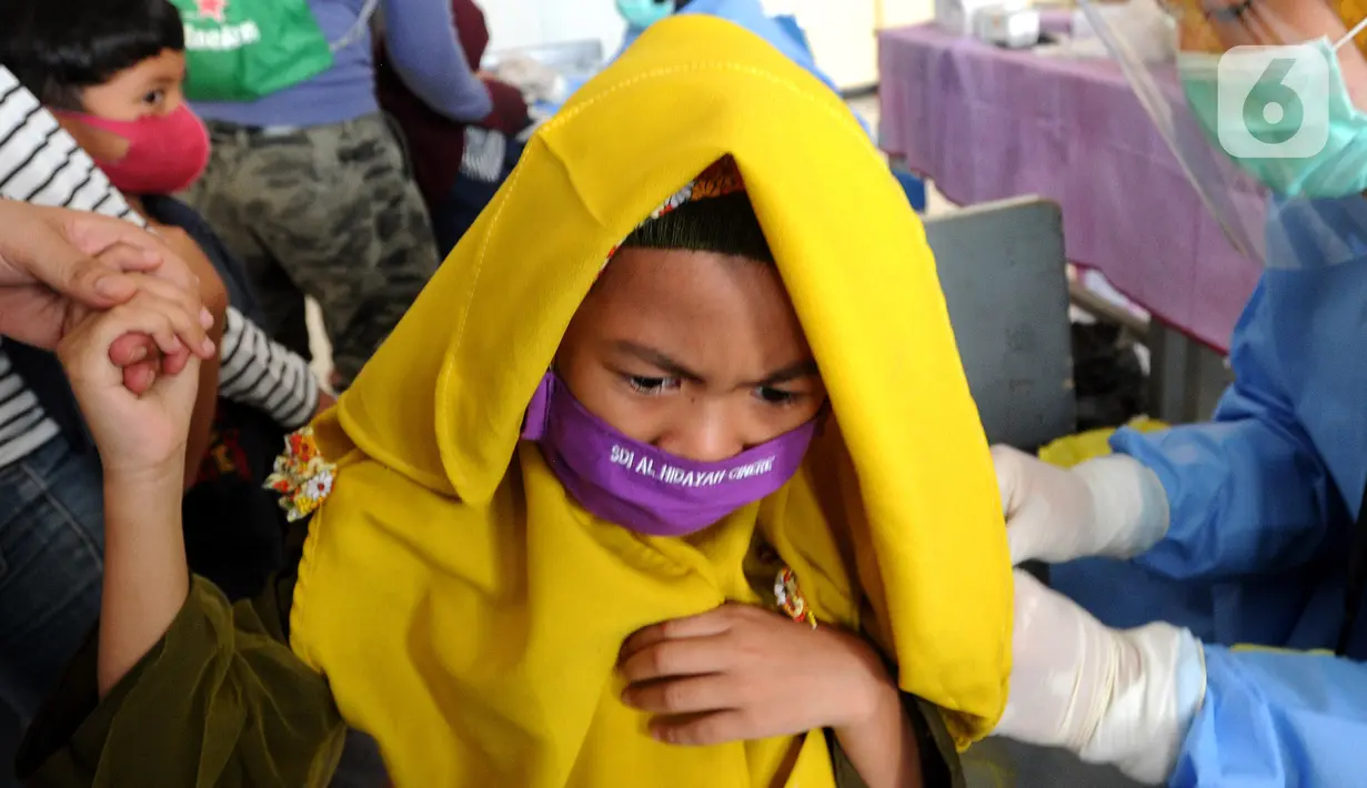 Siswa kelas 1 mendapatkan suntikan vaksin tetanus difteri (TD) di SDI Al Hidayah, Cinere, Depok, Jumat (20/11/2020). Program imunisasi kepada pelajar di Kota Depok terus berjalan guna menjaga kesehatan anak dan meningkatkan imunitas tubuh di masa pandemi COVID-19. (merdeka.com/Arie Basuki)