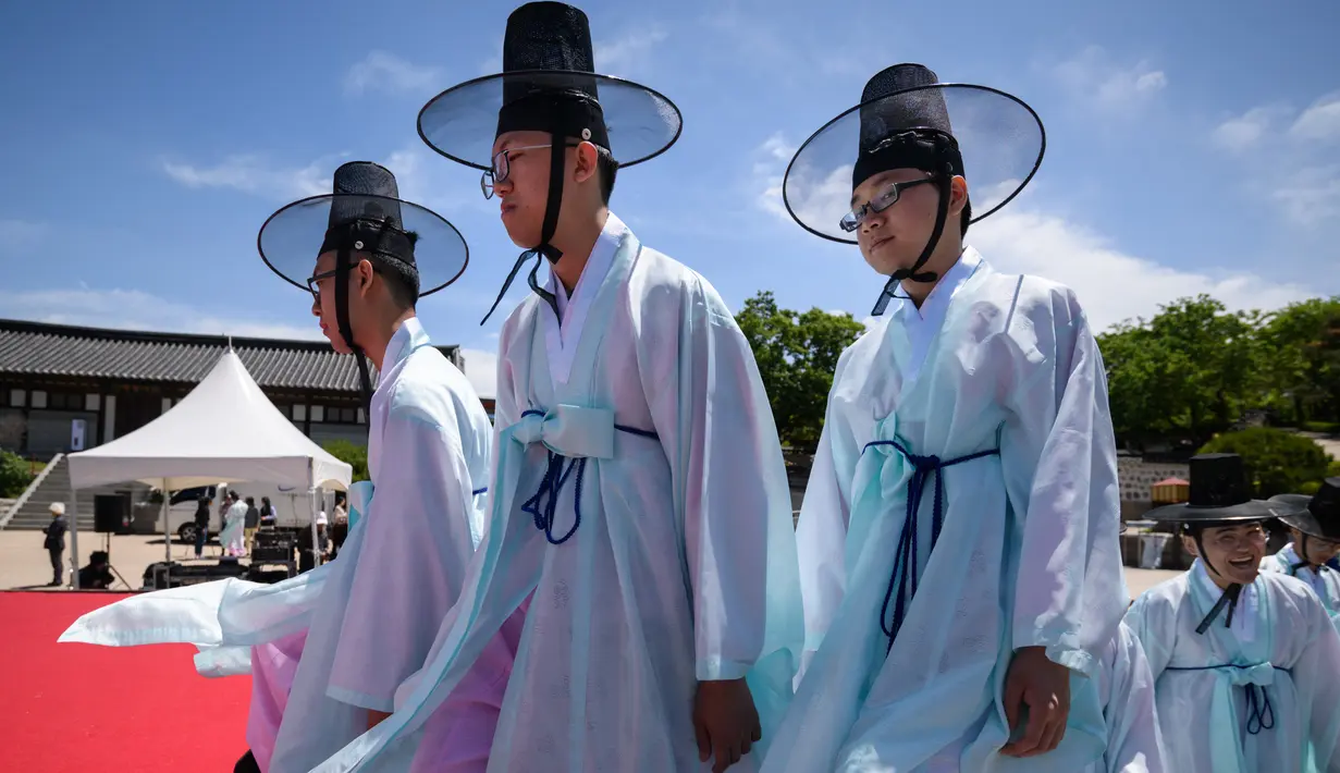 Para pria muda mengenakan pakaian tradisional untuk menghadiri upacara “Coming of Age” di Namsan Hanok Village, Seoul, Senin (20/5/2019). Di Korea Selatan, Coming of Age Day atau hari kedewasaan dirayakan secara nasional setiap tahun pada hari Senin ketiga di bulan Mei. (Ed JONES/AFP)
