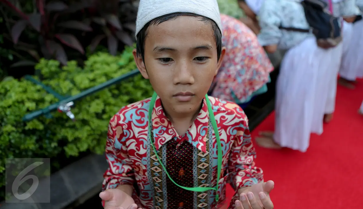 Seorang anak yatim terlihat berdoa usai mengambil air wudhu, Jakarta, Kamis (18/6/2015). Jokowi mengundang 400 anak yatim dari 12 panti asuhan yang ada di Jabodetabek untuk berbuka puasa bersama di Isatana Negara (Liputan6.com/Faizal Fanani)