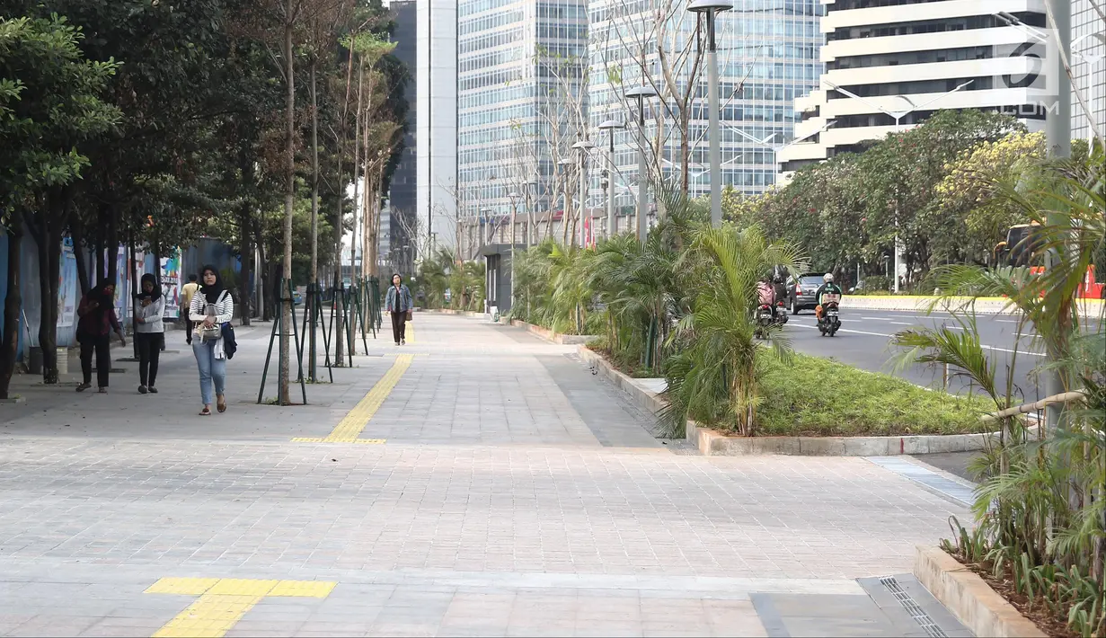Warga berjalan di pedestrian kawasan Sudirman, Jakarta, Sabtu (11/8). Menjelang Asian Games 2018, pedestrian di kawasan Sudirman sudah dapat dinikmati masyarakat. (Liputan6.com/Herman Zakharia)