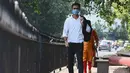 Seorang pria mengenakan masker berjalan di sepanjang jalan di New Delhi (16/9/2020). Total kasus Covid-19 di India melampaui lima juta pada 16 September, data kementerian kesehatan menunjukkan Pandemi meluas cengkeramannya di negara tersebut. (AFP/Sajjad Hussan)