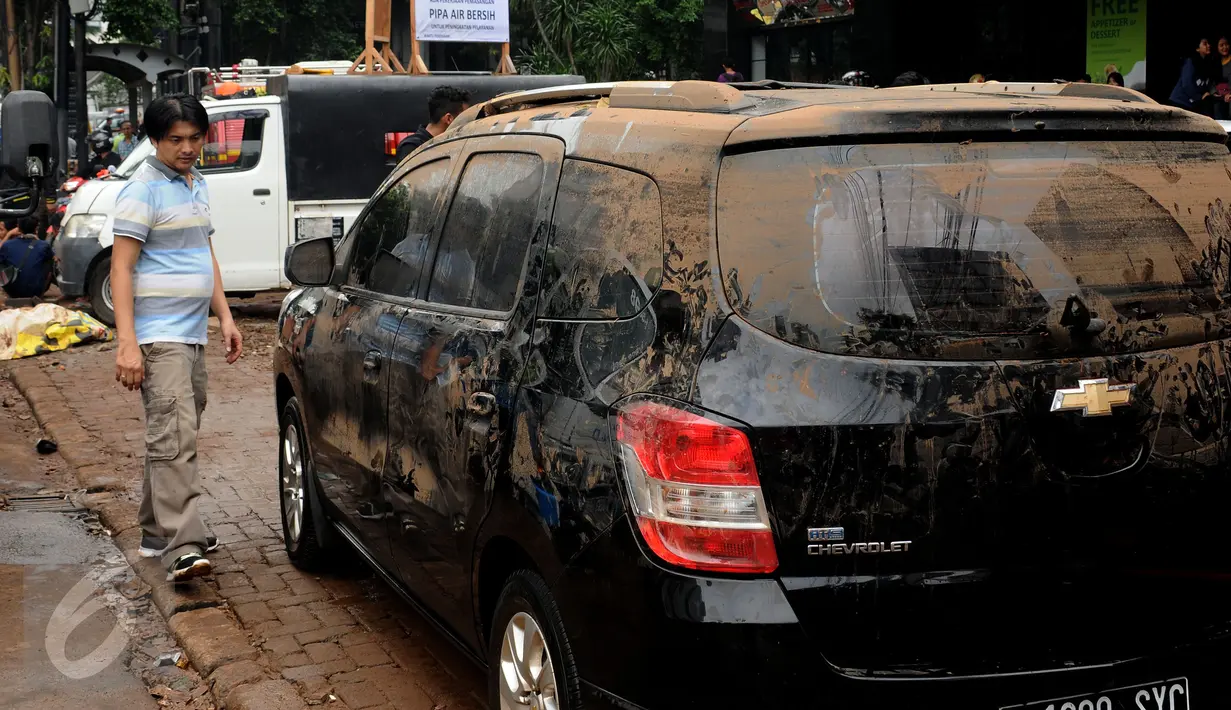 Warga mengecek kondisi kendaraannya setelah terjebak banjir di basement pertokoan di Jalan Kemang Raya, Minggu (28/8). Sejumlah kendaraan terendam air di kawasan Kemang pasca hujan deras di Jakarta, Sabtu (27/8). (Liputan6.com/Helmi Fithriansyah)