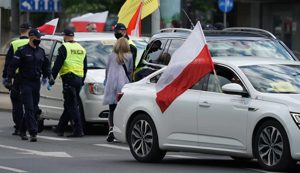 Para pengusaha memblokir jalan dengan mobil mereka saat berdemonstrasi di Warsawa, Polandia, Kamis (7/5/2020). Para pengusaha mendesak pemerintah lebih banyak dalam membantu bisnis mereka agar mampu bertahan menghadapi pandemi virus corona COVID-19.(JANEK SKARZYNSKI/AFP)