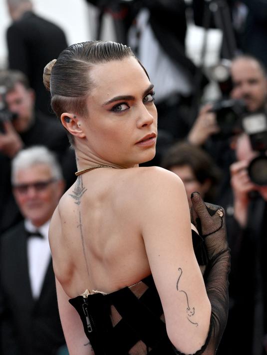<p>Model Inggris Cara Delevingne tiba untuk pemutaran film "The Innocent (L'Innocent)" selama Festival Film Cannes edisi ke-75 di Cannes, Prancis selatan (24/5/2022). Cara Delevingne menarik perhatian dalam gaun hitam yang pas dengan bentuk tubuh. (AFP/Loic Venance)</p>