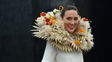 Seorang model berpose untuk foto mengenakan rangkaian bunga selama RHS Chelsea Flower Show 2021 di London pada Senin (20/9/2021). Pertunjukan bunga ChelseA sempat ditunda dari tanggal musim semi biasanya karena pembatasan penguncian di tengah penyebaran pandemi COVID-19. (JUSTIN TALLIS/AFP)