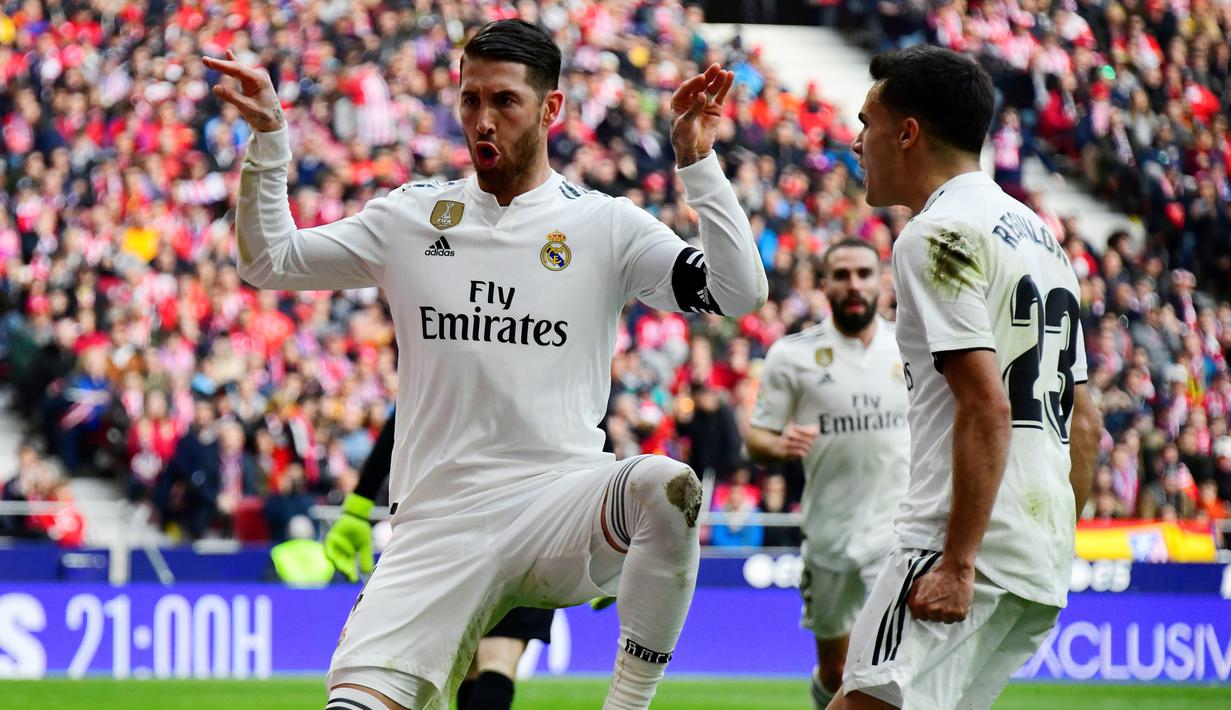 Bek Real Madrid, Sergio Ramos (kiri) berselebrasi usai mencetak gol ke gawang Atletico de Madrid pada pertandingan lanjutan La Liga Spanyol di stadion Wanda Metropolitano (9/2). Real Madrid menang 3-1 atas Atletico. (AFP Photo/Gabriel Bouys)