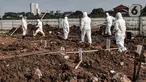 Petugas Sudin Pertamanan dan Hutan Kota Jakarta Utara mengenakan baju hazmat bersiap memakamkan jenazah pasien Covid-19 di TPU Rorotan, Jakarta, Minggu (28/3/2021). TPU Rorotan mulai difungsikan sebagai tempat pemakaman jenazah pasien Covid-19 ber-KTP DKI Jakarta. (merdeka.com/Iqbal S. Nugroho)