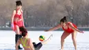 Sejumlah wanita mengenakan pakaian renang bermain bola di lapangan bersalju di Shenyang, Provinsi Liaoning, Tiongkok (8/3). Mereka mengenakan pakaian renang bermain bola ketika peringatan Hari Perempuan Internasional. (AFP Photo/China Out)