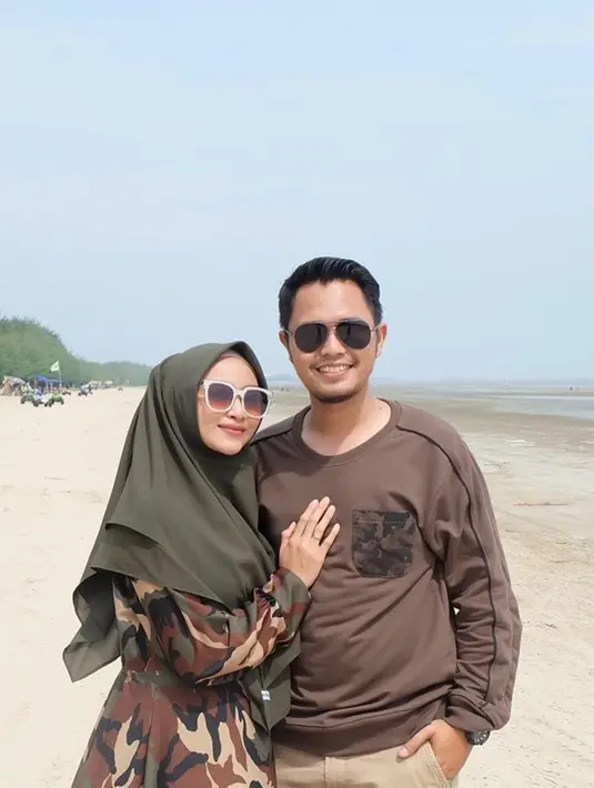 Ketika liburan di pantai, Fida D'Academy dan sang suami tampil serasai dengan busana warna senada. Sama-sama mengenakan kacamata, keduanya tampak begitu kompak.(Liputan6.com/IG/@fida310)
