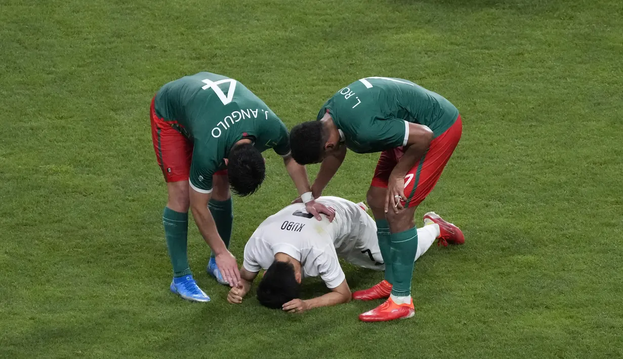 Atlet Meksiko Jesus Angulo dan rekan setimnya Luis Romo menghibur atlet Jepang Takefusa Kubo setelah pertandingan sepak bola medali perunggu putra pada Olimpiade Tokyo 2020 di Saitama, Jepang, 6 Agustus 2021. (AP Photo/Gregorio Borgia)