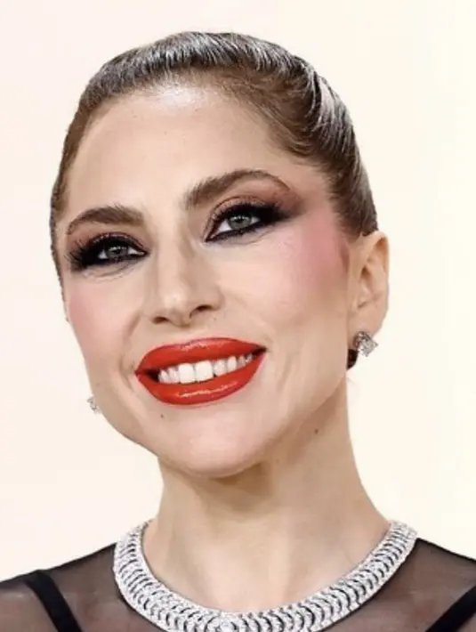 Lady Gaga tampil di Vanity Fair Oscar Party dengan gaun hitam Versace yang beberapa hari lalu dipakai Gigi Hadid untuk pertunjukan Fall/Winter 2023. Tak kalah dengan sang supermodel, penyanyi ‘Hold My Hand’ itu menaklukkan gaun menerawang yang seksi.  (Foto: Instagram/ Lady Gaga).