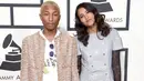 Pharrell Williams dan istrinya, Helen Lasichanh, berpose di karpet merah Grammy Awards 2016 di Los Angeles, Senin (15/2). Rapper 42 tahun itu mengenakan jeans beraksen sobekan dipadukan jaket coklat tak berkerah. (Jason Merritt/Getty Images for NARAS/AFP)