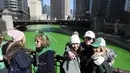 Orang-orang mengambil foto di State Street Bridge setelah pewarnaan Sungai Chicago di Chicago, Sabtu (12/3/2022). Perubahan warna ini dilakukan untuk menyambut Hari St. Patrick pada Kamis mendatang.  (John J. Kim/Chicago Tribune via AP)