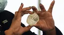 Seorang anggota kabinet Botswana memegang berlian permata di Gaborone, ibu kota Botswana, Rabu (16/6/2021). Penemuan ini terjadi pada masa yang krusial, saat penjualan berlian selama tahun 2020 anjlok akibat pandemi Covid-19. (Monirul Bhuiyan/AFP)