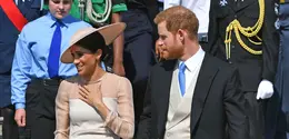 Duke dan Duchess of Sussex, Pangeran Harry dan Meghan Markle menghadiri pesta kebun Istana Buckingham di London, Selasa (22/5). Meghan juga memakai stocking warna kulit, mengikuti cara berbusana Putri Inggris lainnya. (Dominic Lipinski/Pool Photo via AP)