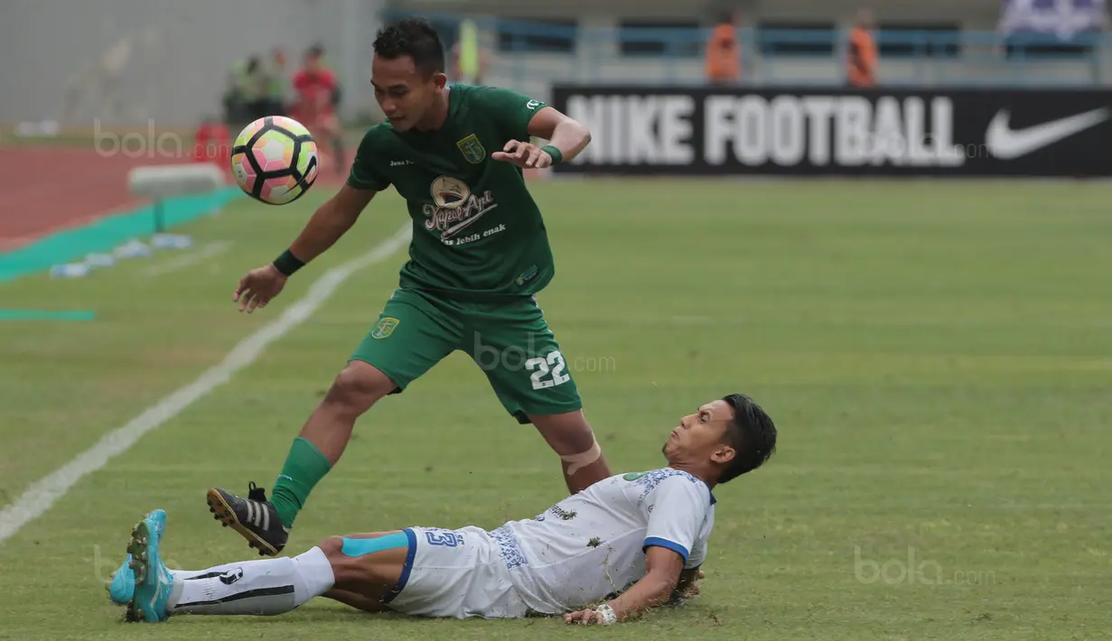 Pemain Persebaya, Abu Rizal Maulana (atas) diadang pemain pemain PSPS Riau, Asep Santoso pada laga 8 Besar Liga 2 Grup Y di Stadion GBLA, Bandung, Sabtu (18/11/2017). Persebaya Menang 1-0. (Bola.com/Nicklas Hanoatubun)