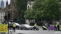 Polisi menahan seorang pengunjuk rasa yang berlari ke arah mobil Perdana Menteri Boris Johnson ketika meninggalkan Gedung Parlemen. (AFP / DANIEL LEAL-OLIVAS)