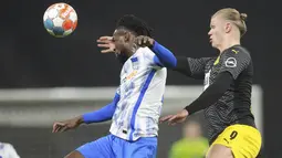 Bek Hertha Berlin Jordan Torunarigha berebut bola dengan penyerang Borussia Dortmund Erling Haaland pada laga pekan ke-17 Liga Jerman di Olympiastadion, Minggu (19/12/2021) dinihari WIB. Tuan rumah Hertha Berlin mempermalukan Dortmund dengan skor 3-2. (AP Photo/Michael Sohn)