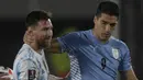 Penyerang Argentina Lionel Messi menyapa penyerang Uruguay Luis Suarez sebelum laga Kualifikasi Piala Dunia 2022 Zona Amerika Selatan di Monumental stadium, Senin (11/10/2021) pagi WIB. Duel ini menjadi momen reuni dua mantan pemain Barcelona, Messi dan Suarez. (Juan Mabromata/AFP)