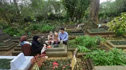 Ziarah makam merupakan tradisi dilakukan sebagian besar masyarakat Indonesia untuk mendoakan keluarga yang telah wafat dan membersihkan pusara. Tampak dalam foto, warga saat berziarah di makam keluarganya di Tempat Pemakaman Umum (TPU) Dreded, Bogor, Jawa Barat, Minggu (15/2/2026). (merdeka.com/Arie Basuki)