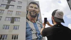 Seniman jalanan Argentina Maximiliano Bagnasco mengambil foto mural yang menggambarkan superstar sepak bola Argentina Lionel Messi, yang ia lukis, di Tirana, Albania, pada Kamis (8/6/2023). (AP Photo/Llazar Semini)