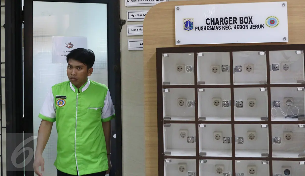 Petugas berjalan di samping charger box yang berada di Puskesmas Kecamatan Kebon Jeruk, Jakarta, Selasa (18/10). Puskesmas empat lantai ini menjadi viral di media sosial karena berbagai fasilitas kesehatan yang disediakan. (Liputan6.com/Immanuel Antonius)