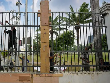 Para pekerja memasang kembali pagar besi kompleks parlemen yang dijebol oleh para demonstran pada hari sebelumnya, di Jakarta pada 23 Agustus 2024. (BAY ISMOYO/AFP)